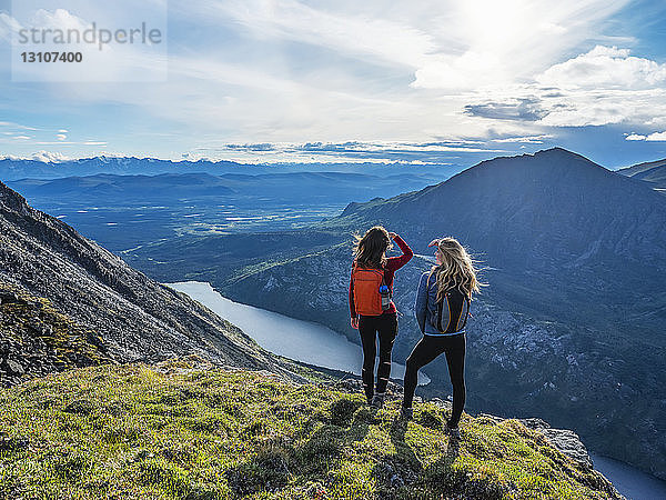 Zwei Frauen erkunden die Berge und die Wildnis des Yukon. Sie fühlen sich lebendig und dynamisch in der wunderschönen Landschaft um Haines Junction; Yukon  Kanada