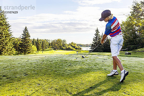 Ein junger männlicher Golfer schlägt während eines Turniers auf einem Golfplatz einen Ball über das Fairway; Edmonton  Alberta  Kanada