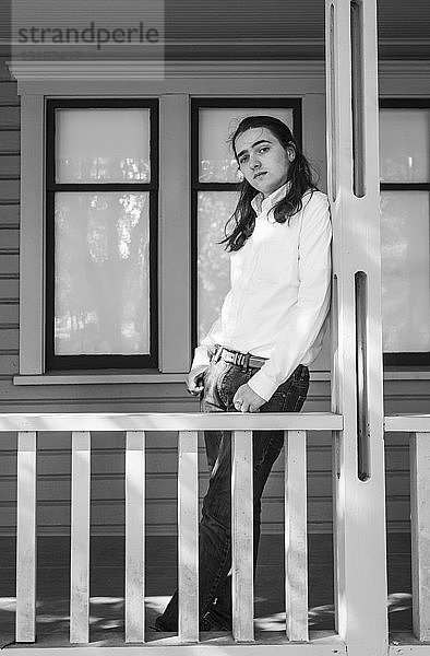Porträt eines Teenagers  der auf der Veranda eines Hauses steht; Bothell  Washington  Vereinigte Staaten von Amerika