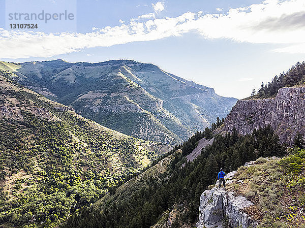 Ein Mann steht auf einem Bergrücken und blickt auf die Berge und Täler unter ihm; Logan  Utah  Vereinigte Staaten von Amerika
