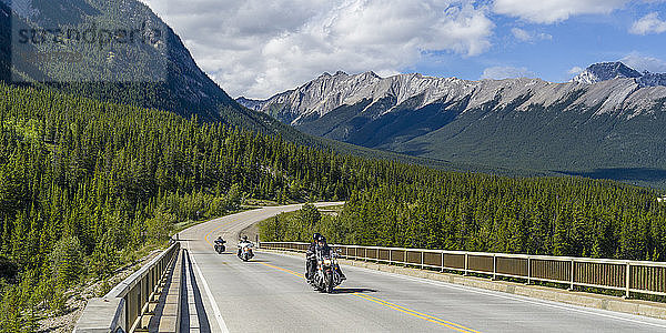 Motorradfahrer fahren auf einer Straße durch die zerklüfteten kanadischen Rocky Mountains im Jasper National Park; Alberta  Kanada