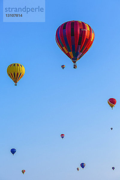 Niedriger Blickwinkel auf bunte Heißluftballons in einem blauen Himmel; St. Jean sur Richelieu  Quebec  Kanada