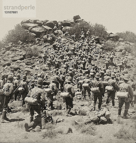 Viktorianische Stereoview-Karte von ca. 1900 zur Betrachtung eines Stereoskops. Südafrikanischer Krieg  auch Burenkrieg  Zweiter Burenkrieg oder Anglo-Burenkrieg genannt; für die Afrikaner auch Zweiter Unabhängigkeitskrieg genannt  Krieg  der vom 11. Oktober 1899 bis zum 31. Mai 1902 zwischen Großbritannien und den beiden Burenrepubliken (Afrikaner) - der Südafrikanischen Republik (Transvaal) und dem Oranje-Freistaat - geführt wurde. Methuens tapfere Infanterie stürmt das Kopje bei Gras Pan  Südafrika