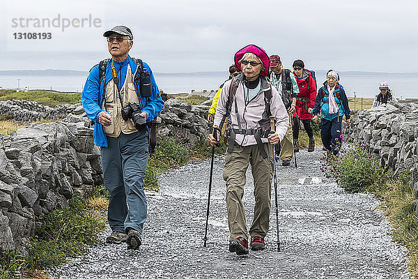 Touristen besuchen die prähistorische Festung Dun Aonghasa  die auf einer hohen Klippe thront  Inishmore  Aran-Inseln; Kilronan  County Galway  Irland