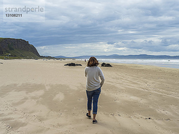 Frau beim Spaziergang am Downhill Beach  Nordirland; Castlerock  Grafschaft Londonderry  Irland
