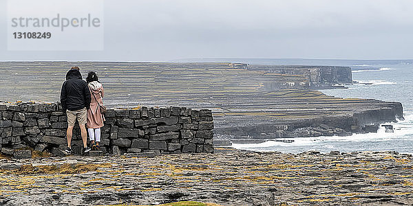 Touristen besuchen die prähistorische Festung Dun Aonghasa  die auf einer hohen Klippe thront  Inishmore  Aran-Inseln; Kilronan  County Galway  Irland