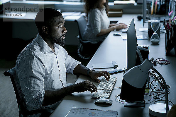 Geschäftsleute  die an Desktop-Computern am Schreibtisch im Büro arbeiten