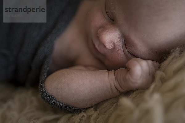 Schrägansicht eines zu Hause auf dem Teppich schlafenden Jungen