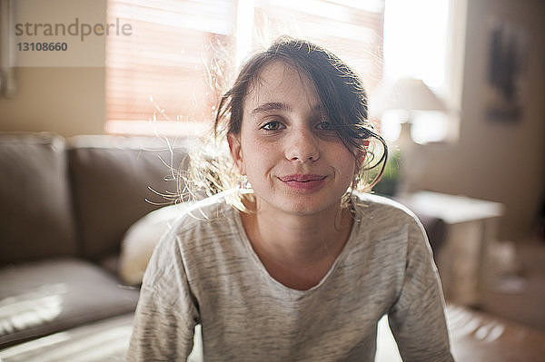 Porträt eines lächelnden Mädchens  das zu Hause sitzt