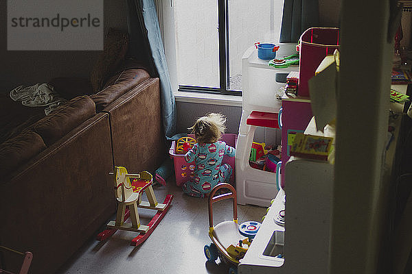 Hochwinkelaufnahme eines Mädchens  das zu Hause mit Spielzeug spielt