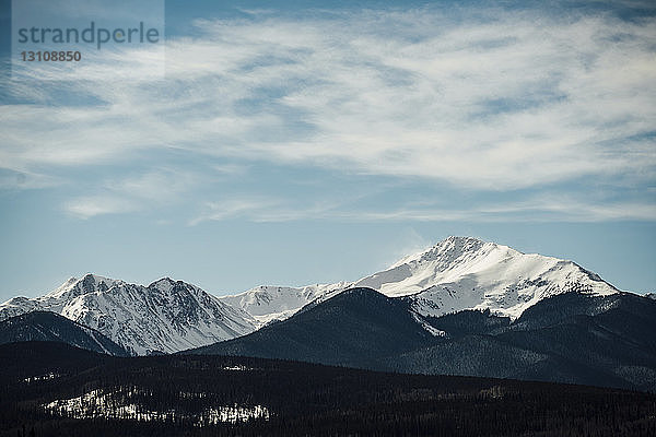 Majestätischer Blick auf schneebedeckte Berge vor bewölktem Himmel