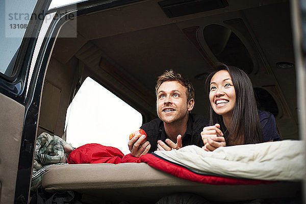 Glückliches Paar auf dem Rücksitz eines Wohnwagens