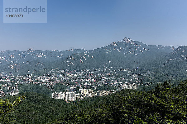 Luftaufnahme der Stadtlandschaft inmitten von Bergen vor klarem blauen Himmel