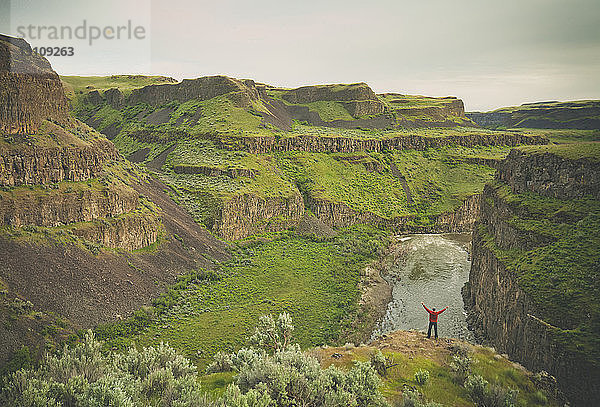 Rückansicht eines Mannes mit ausgestreckten Armen im Palouse Falls State Park