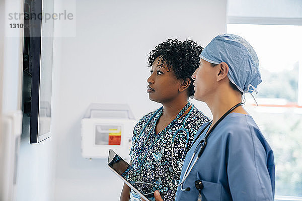 Ärzte  die bei der Arbeit im Krankenhaus auf einen Flachbildschirm schauen