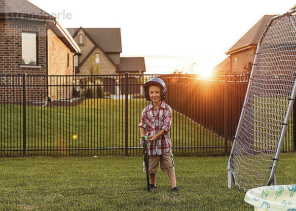 Porträt eines Jungen mit Baseballschläger im Hinterhof