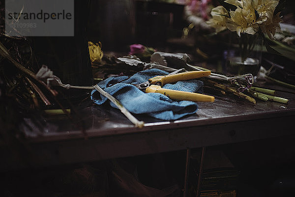 Nahaufnahme einer Zange mit Serviette bei Blumen auf einem Tisch im Laden