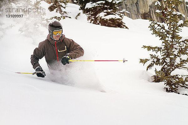 Skifahrer auf verschneiter Piste am Berg