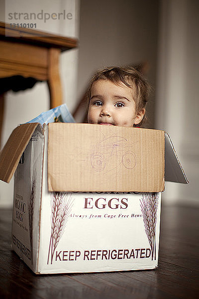 Porträt eines kleinen Mädchens  das in einer Kiste sitzt