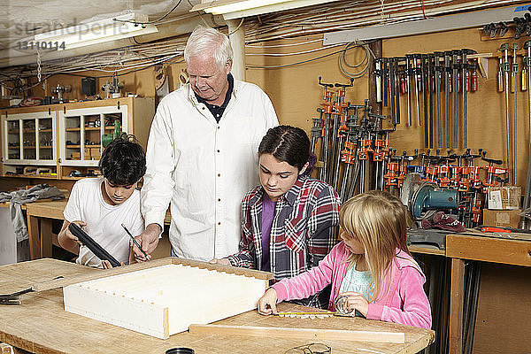 Zimmermann unterrichtet Studenten in einer Werkstatt
