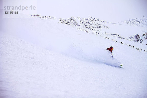 Mann beim Skifahren auf der Schneepiste