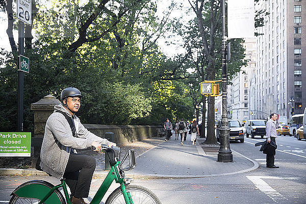 Mann schaut weg  während er auf der Stadtstraße Fahrrad fährt