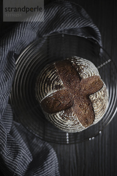 Draufsicht auf frisch gebackenen Brotlaib auf Metallrost