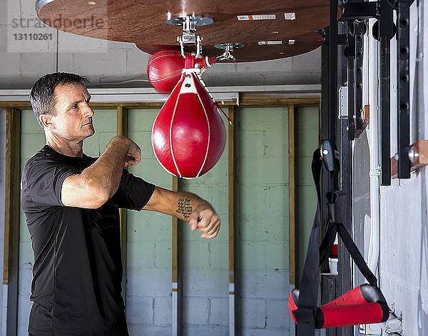 Box-Trainer beim Boxen mit dem Boxsack in der Turnhalle