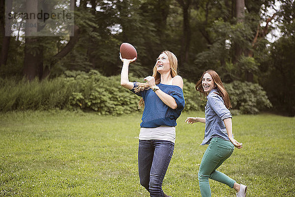 Freundinnen spielen Fussball auf Rasen