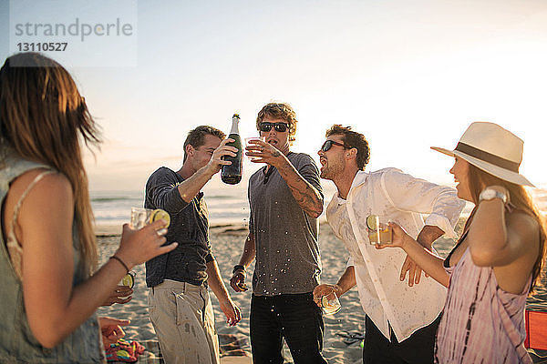 Fröhliche Freunde genießen Drinks am Strand