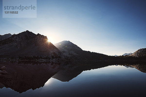 Szenische Ansicht des Sees mit Spiegelung der Berge vor klarem Himmel