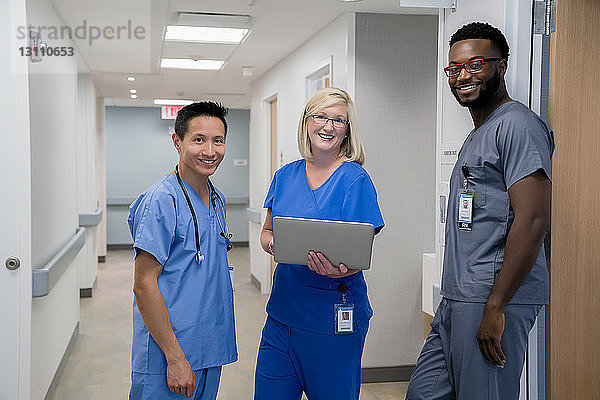 Porträt von selbstbewussten Ärzten  die im Krankenhauskorridor stehen