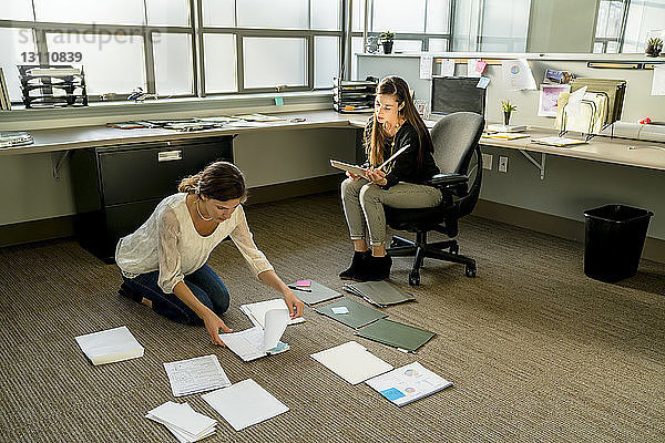 Geschäftsfrauen ordnen Dokumente auf dem Boden im Büro an