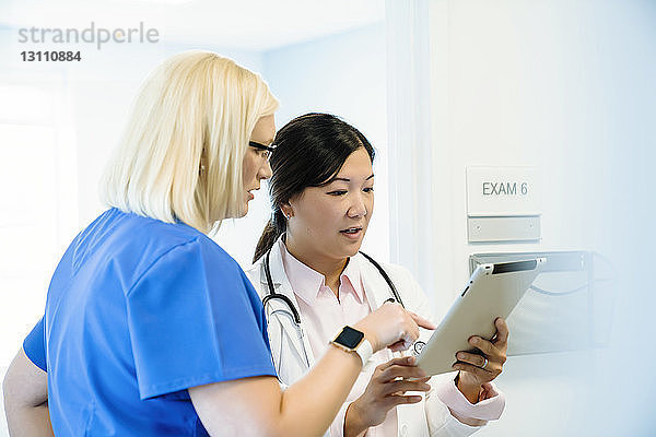 Seriöse Ärztinnen diskutieren über Tablet-Computer im Krankenhaus