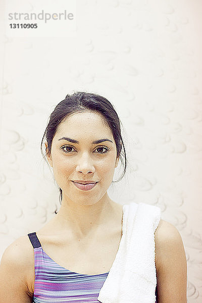 Porträt einer lächelnden jungen Frau im Fitnessstudio