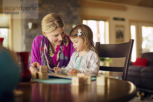 Mutter unterrichtet Tochter zu Hause auf dem Tisch