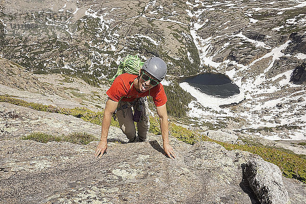 Hochwinkelporträt eines Wanderers  der am Fels klettert