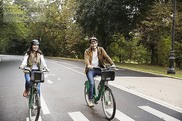 Fröhliches Ehepaar beim Fahrradfahren auf der Straße im Park