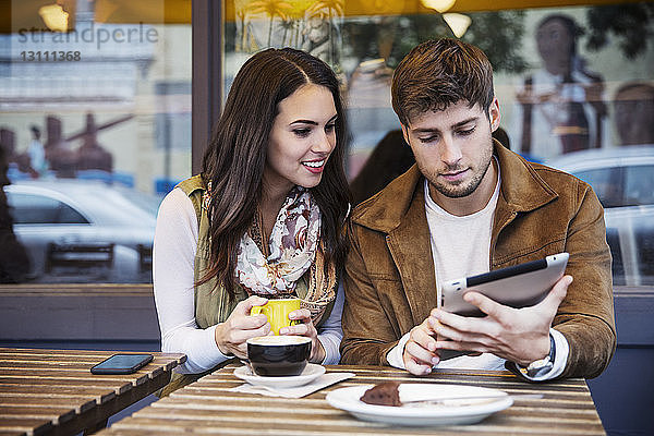 Paar benutzt einen Tablet-Computer  während es im Café sitzt