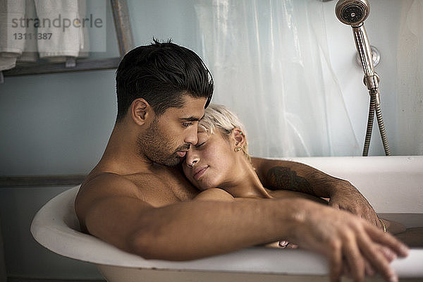 Junges Paar entspannt sich zu Hause in der Badewanne
