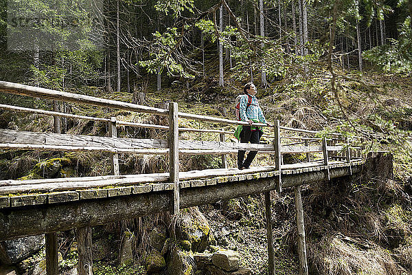 Weibliche Wanderin auf Steg im Wald stehend