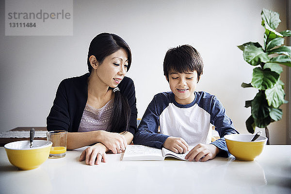 Mutter unterrichtet Sohn zu Hause auf dem Tisch