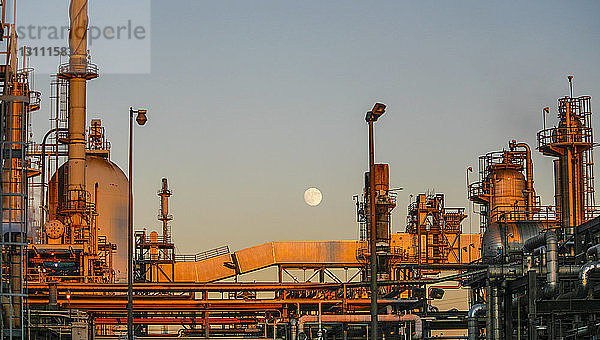 Raffinerie-Lagertanks gegen klaren Himmel bei Sonnenuntergang