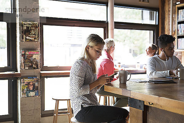 Männliche und weibliche Kunden entspannen sich an sonnigen Tagen im Café