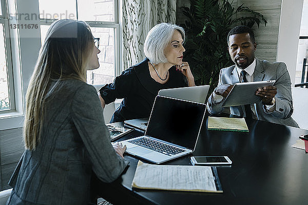 Geschäftsmann zeigt weiblichen Kollegen im Büro Tablet-Computer