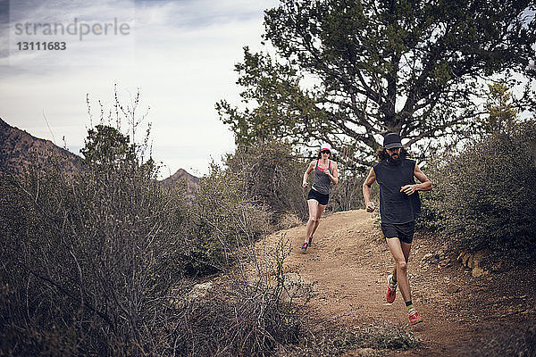 Sportliches Paar läuft am Berg