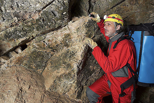 Archäologe mit Rucksack in Höhle stehend