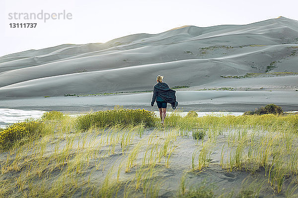 Rückansicht einer Frau inmitten von Pflanzen im Great Sand Dunes National Park