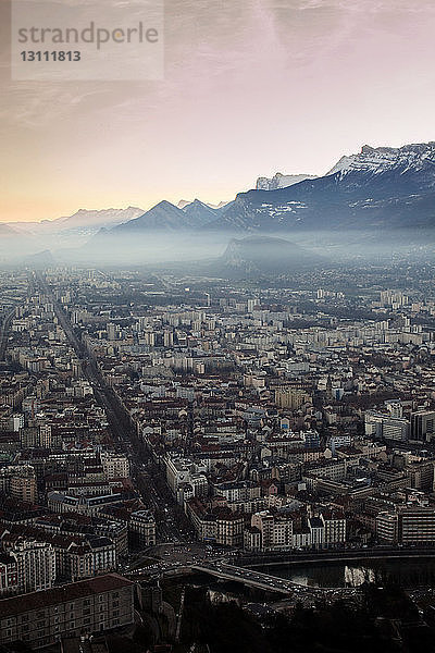 Luftaufnahme der Stadtlandschaft und der Berge gegen den Himmel bei Sonnenaufgang