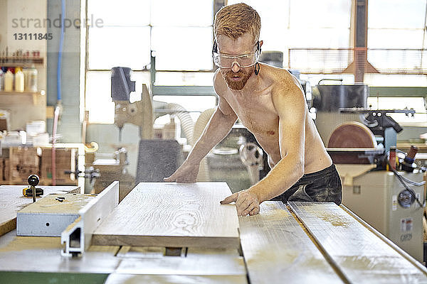 In der Werkstatt arbeitender hemdloser Schreiner